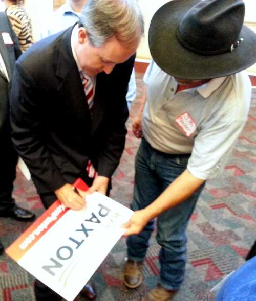 Paxton signs a placard for a local supporter